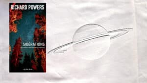A l'arrière-plan, Saturne et ses anneaux, au premier plan, le couverture du livre de Richard Powers, Sidérations