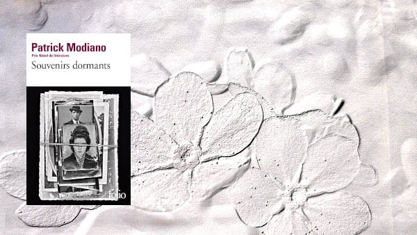 A l'arrière-plan, des myosotis, fleurs du souvenir et au premier plan la couverture du livre de Patrick Modiano, Souvenirs dormants
