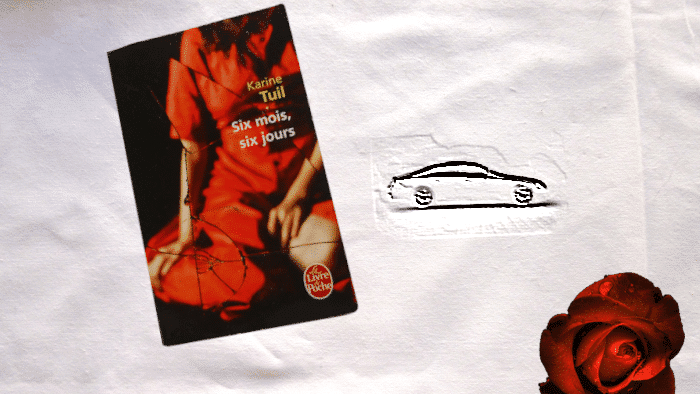 En arrière-plan, une voiture et au premier plan, la couverture du livre de Karine Tuil, Six mois, six jours