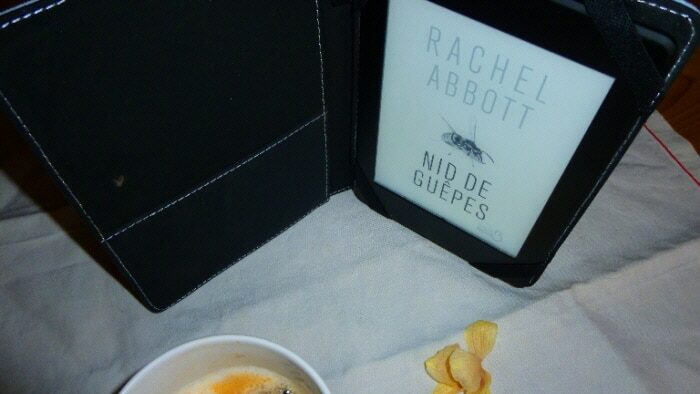 Tasse de café, liseuse avec en couverture le livre de Rachel Abbott, Nid de guêpes
