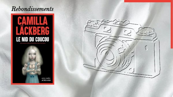 Un appareil photo en arrière-plan et au premier plan, la couverture du livre de Camilla Läckberg, Le nid de coucou