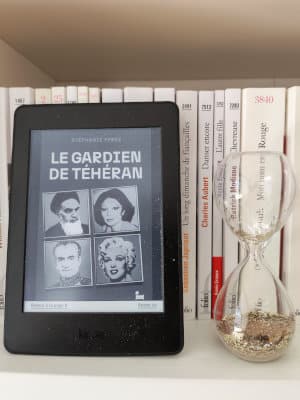 Liseuse posée sur une étagère, avec la page de couverture du livre de Stéphanie Perez, Le gardien de Téhéran