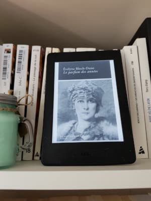Liseuse posée sur une étagère ouverte sur la couverture du livre d'Evelyne Bloch-Dano, Le parfum des années