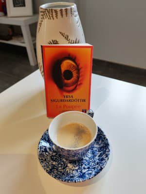 Le livre d'Yrsa Sigurdardottir, La poupée, posée contre un vase. Tasse de café