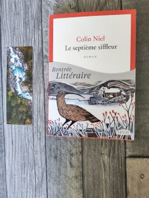 Livre de Colin Niel, Le septième siffleur, posé sur le sol, à côté d'un marque-page