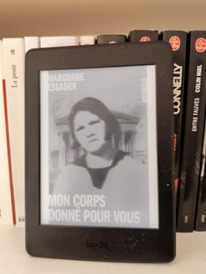 Liseuse posée sur une étagère, ouverte sur la couverture du livre de Marouane Essadek, Mon corps donné pour vous