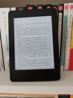 Liseuse sur une étagère de ma bibliothèque avec la première page du livre de Colum McCann, Ce qui nous frôle sous la surface.